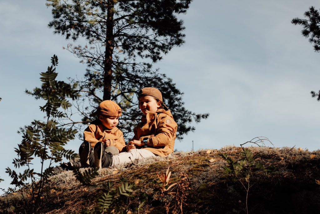Lapset istuvat kalliolla.