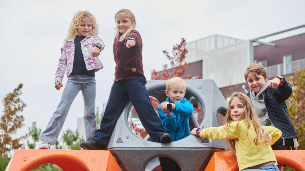Lapset ovat leikkimässä leikkipuistossa. Lapset esittelevät kellopuhelimia leikkipuistossa.